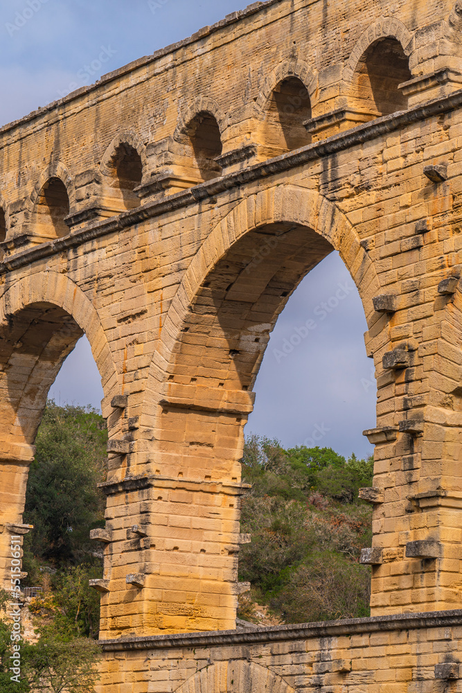 Pont du Gard three-tiered aqueduct from orange limestone, vertical