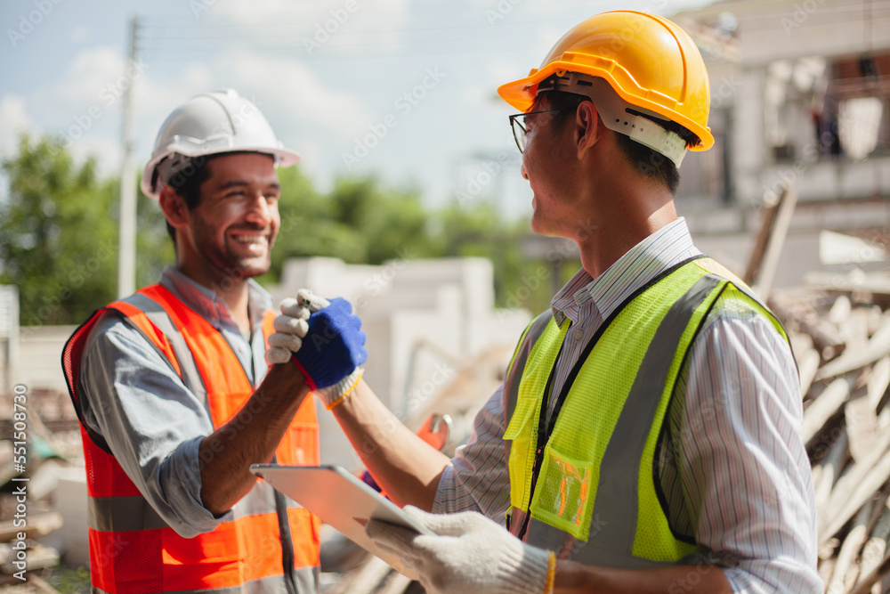 Engineers and workers shaking hands, congratulating success at work. Construction worker after successful background meeting on construction site teamwork professional architect enginee Engineers and workers shaking hands, congratulating success at work. Construction worker after successful background meeting on construction site teamwork professional architect enginee