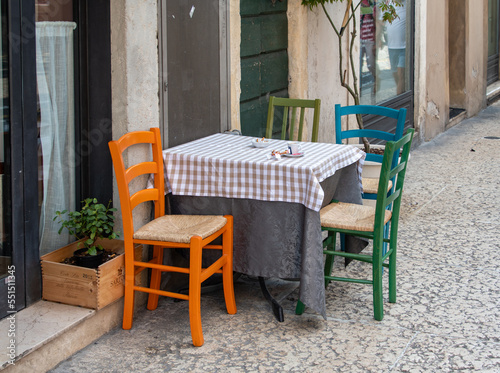Ein kleiner Tisch mit bunten Stühlen vor einem Strassencafe © Dieter