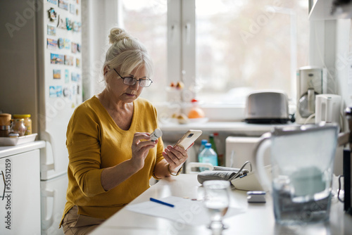 Older woman checking prescription with mobile phone
