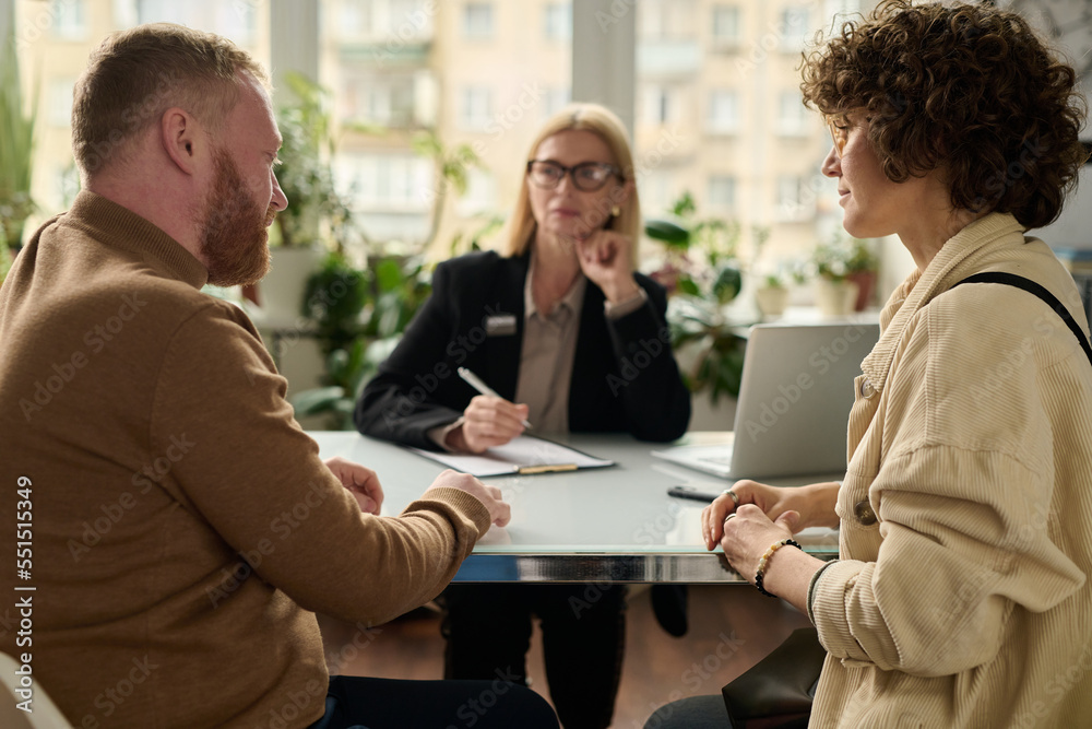 Back view portrait of adult couple consulting attorney in office settling legal matters in marriage Back view portrait of adult couple consulting attorney in office settling legal matters in marriage