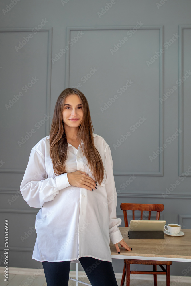 Pretty long-haired pregnant woman at work in the office Pretty long-haired pregnant woman at work in the office