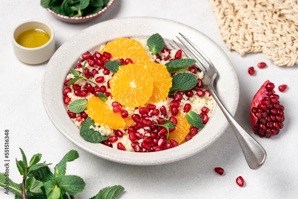 Couscous salad with oranges, pomegranate seeds and mint. Seasonal fruit salad. middle eastern food Couscous salad with oranges, pomegranate seeds and mint. Seasonal fruit salad. middle eastern food