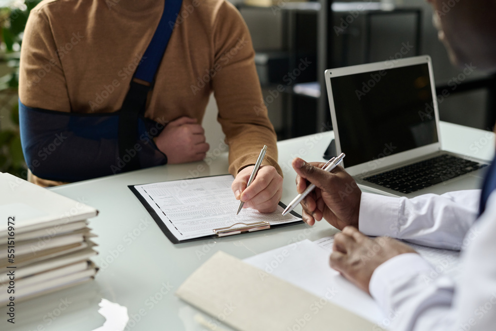 Ταπετσαρία Close up of man filling in medical insurance form, injured hand in sling in back