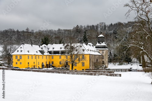 Winter in Sundern Sauerland Germany with historic castle “Schloss Melschede“ near Sundern and Sorpesee Sauerland Germany. Monument sight from 17th century in snowy December scenery and frosted forest. photo