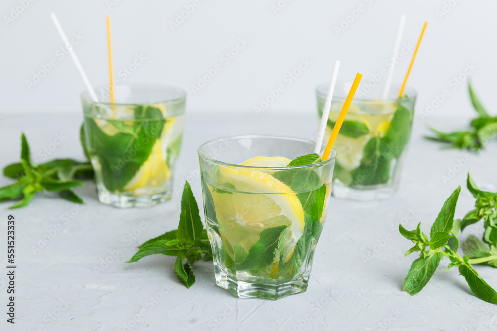 Mojito cocktail. Refreshing mojito cocktail with lime, lemon and mint in a tall glass with a stick Mojito cocktail. Refreshing mojito cocktail with lime, lemon and mint in a tall glass with a stick