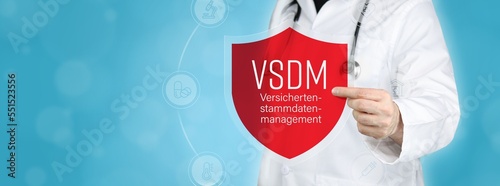 Versichertenstammdatenmanagement (VSDM). Arzt hält rotes Schutzschild umgeben von Icons im Kreis. Medizinisches Wort im Symbol photo