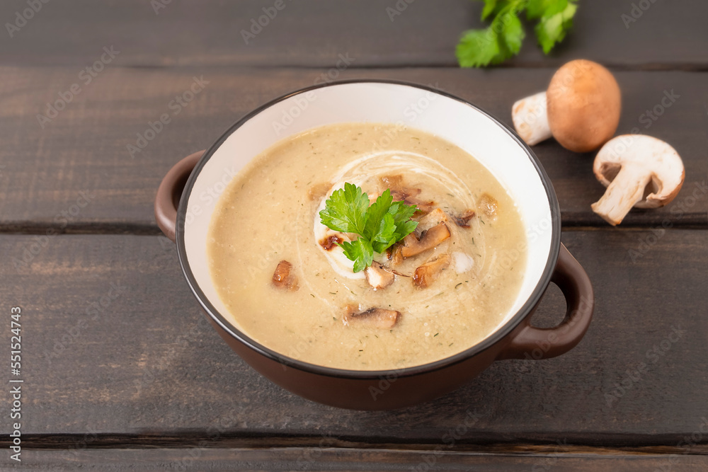 Bowl of mushroom cream soup on wooden table