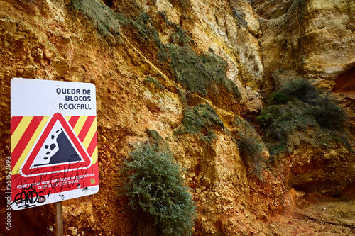 Characteristic cliff with 'Rockfall' - warning sign, Camilo beach, Lagos, Algarve, Faro district, Portugal, Europe  photo