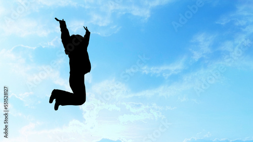 青空にジャンプする女性のシルエット_ワイド