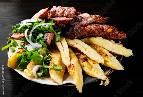 cut Lulia kebab with potato in plate on wooden table background photo