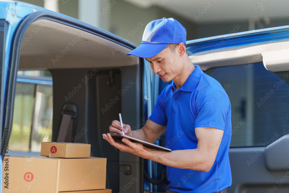 Asian courier with parcel and delivery logistic concept. Delivery man using digital tablet