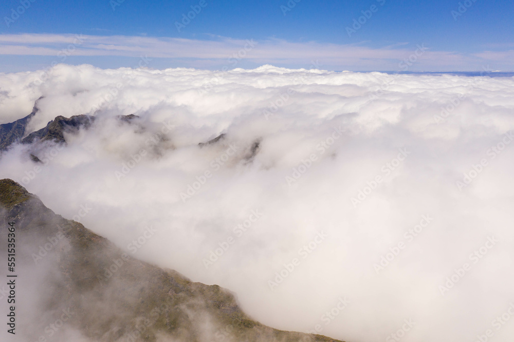 Drone view of mountain peak submerged in fog
