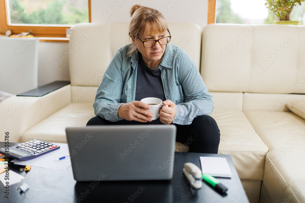 Active mature woman using a laptop for remote work from the home office. Video conference, video meeting. Senior teacher leads webinar Active mature woman using a laptop for remote work from the home office. Video conference, video meeting. Senior teacher leads webinar