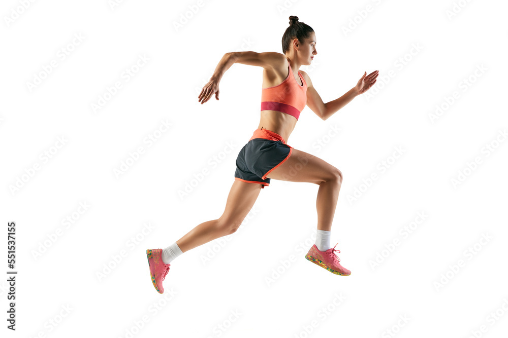 Dynamic portrait of professional female athlete, runner or jogger wearing summer sportswear running isolated on white background. Sport, fitness, motion, competition