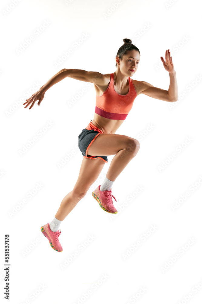 Athlete in motion. Young fitness sportive girl in sports uniform running, training isolated over white background. Dynamic movements, running technique.
