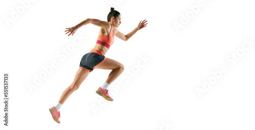 Athlete in motion. Profile view of young fitness sportive girl in sports uniform runnin, training isolated over white backgrund. Running technique.