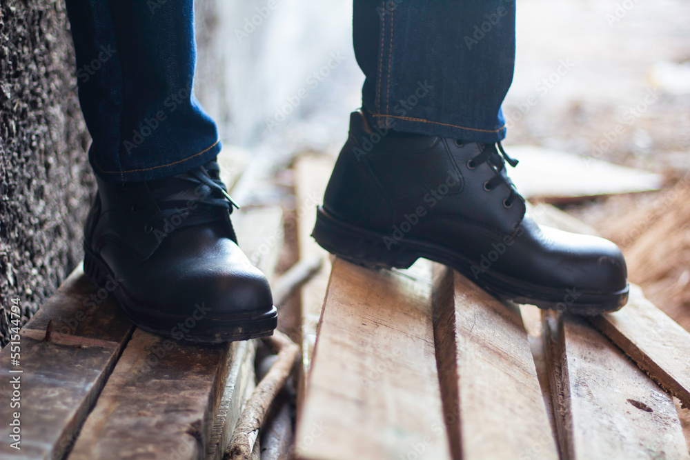 Wear safety shoes to ensure safety at work. construction workers wear safety shoes. concept construction workers work on the stairs Wear safety shoes to ensure safety at work. construction workers wear safety shoes. concept construction workers work on the stairs