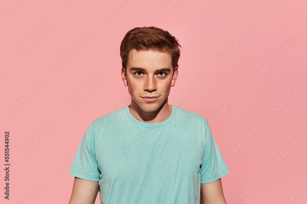 Glad young red hair man standing against pink background Glad young red hair man standing against pink background