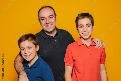 Cheerful single dad smiling and embracing his sons photo