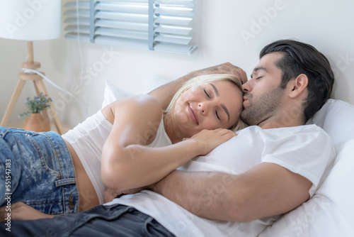Caucasian couple spending together at home, Husband happily hugs and smiles at his wife.
