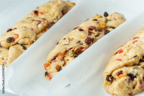 Traditional Christmas Stollen pie is ready for baking in the oven. Making German Christmas bread with raisins and candied fruits . White background. Template for a Christmas pastry recipe
