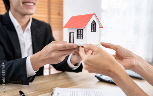 The real estate agent talks to the client about the terms of the home purchase agreement and asks the client to sign the paperwork to complete the sale.