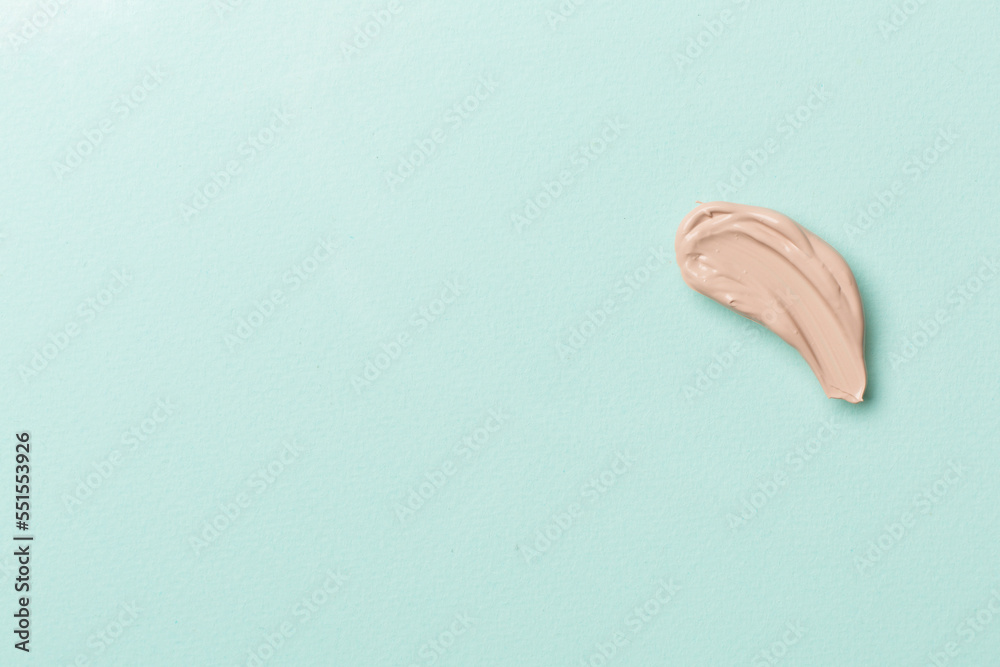 Fototapeta premium Foundation smudge on color background, top view