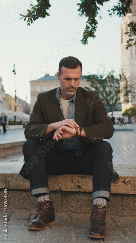 Bearded man sitting on the square of the old town