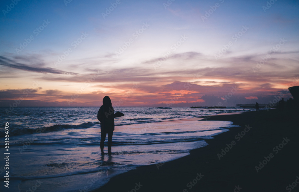 Lonely traveler standing on wet sandy beach