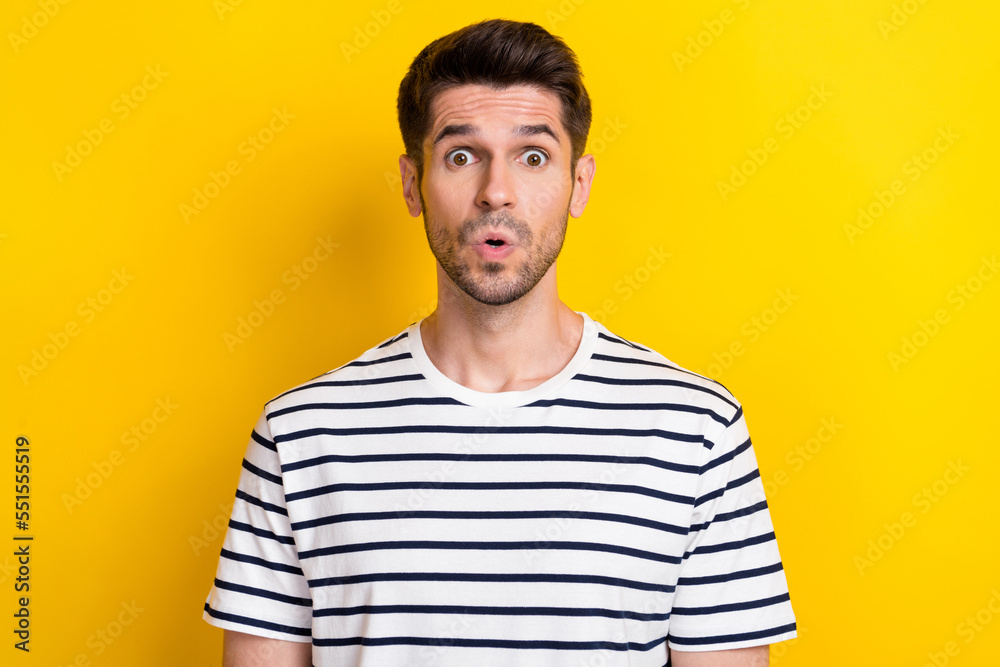Portrait of young handsome student man wear striped white black t-shirt pouted lips surprised secret information isolated on yellow color background