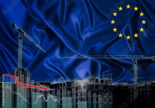 Construction cranes on the background of the EU flag. The concept of a crisis in construction.