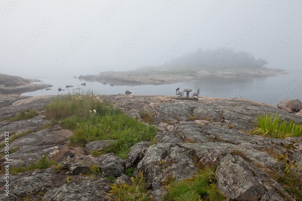 Rocky seashore in foggy weather in summer on the island of Kaparen, Espoo, Finland.