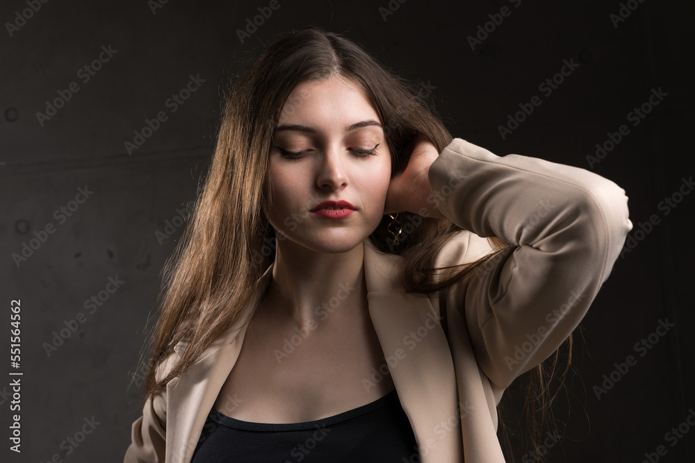 Portrait of a young brunette with long hair in the studio. Dramatic photo in dark colors. Portrait of a young brunette with long hair in the studio. Dramatic photo in dark colors.
