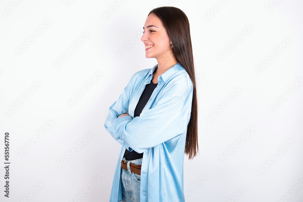 Young caucasian woman wearing blue overshirt over white background cross hands look copy space Young caucasian woman wearing blue overshirt over white background cross hands look copy space