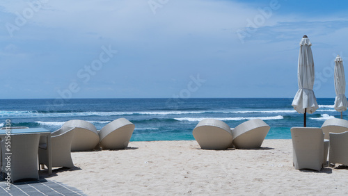 several beach chairs and umbrella packed closed at the beach during summer time