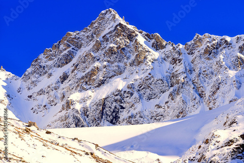 Winter snowy mountains. High snowy sunlight mountain and blue sky at winter, high contrast. Caucasus Mountains. International Mountain Day - 11 December. International Mountaineering Day - 8 August photo