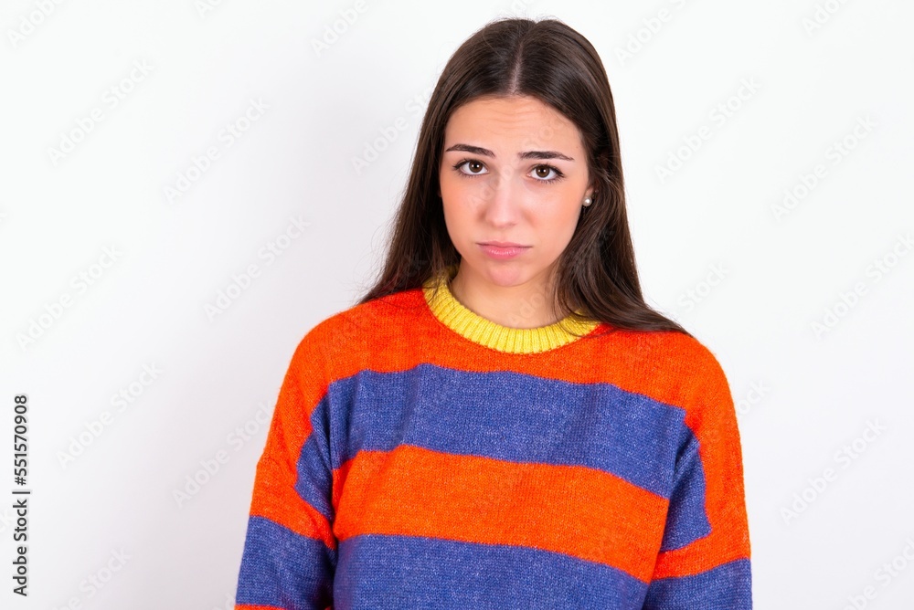 Displeased upset Young caucasian woman wearing colorful knitted sweater over white frowns face as going to cry, being discontent and unhappy as can't achieve goals, Disappointed model has troubles Displeased upset Young caucasian woman wearing colorful knitted sweater over white frowns face as going to cry, being discontent and unhappy as can't achieve goals, Disappointed model has troubles
