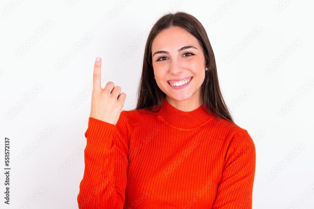 Young caucasian woman wearing red sweater over white background smiling and looking friendly, showing number one or first with hand forward, counting down Young caucasian woman wearing red sweater over white background smiling and looking friendly, showing number one or first with hand forward, counting down
