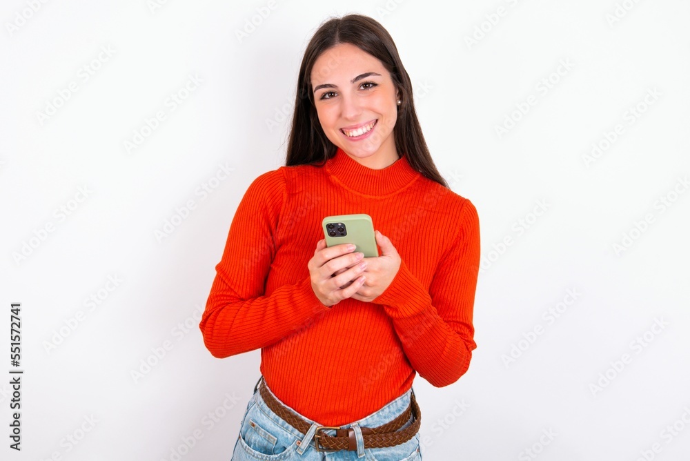 Young caucasian woman wearing red sweater over white background Mock up copy space. Using mobile phone, typing sms message Young caucasian woman wearing red sweater over white background Mock up copy space. Using mobile phone, typing sms message