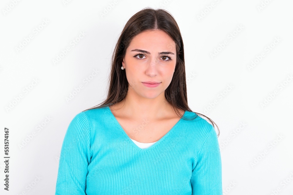 Displeased Young caucasian woman wearing blue sweater over white background frowns face feels unhappy has some problems. Negative emotions and feelings concept Displeased Young caucasian woman wearing blue sweater over white background frowns face feels unhappy has some problems. Negative emotions and feelings concept