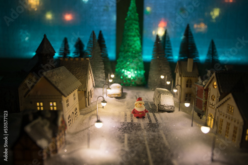 Little decorative cute small houses in snow at night in winter, Christmas and New Year miniature house in the snow at night with fir tree. Holiday concept.