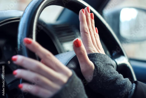 female hands press the horn in the car