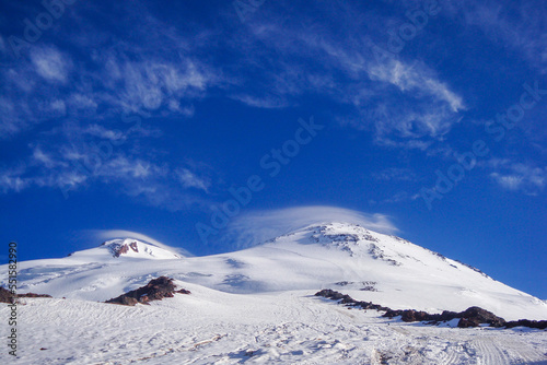 Mount Elbrus in the winter. Slopes are covered with snow above deep blue sky. International Mountain Day - 11 December. International Mountaineering Day - 8 August © Olivia