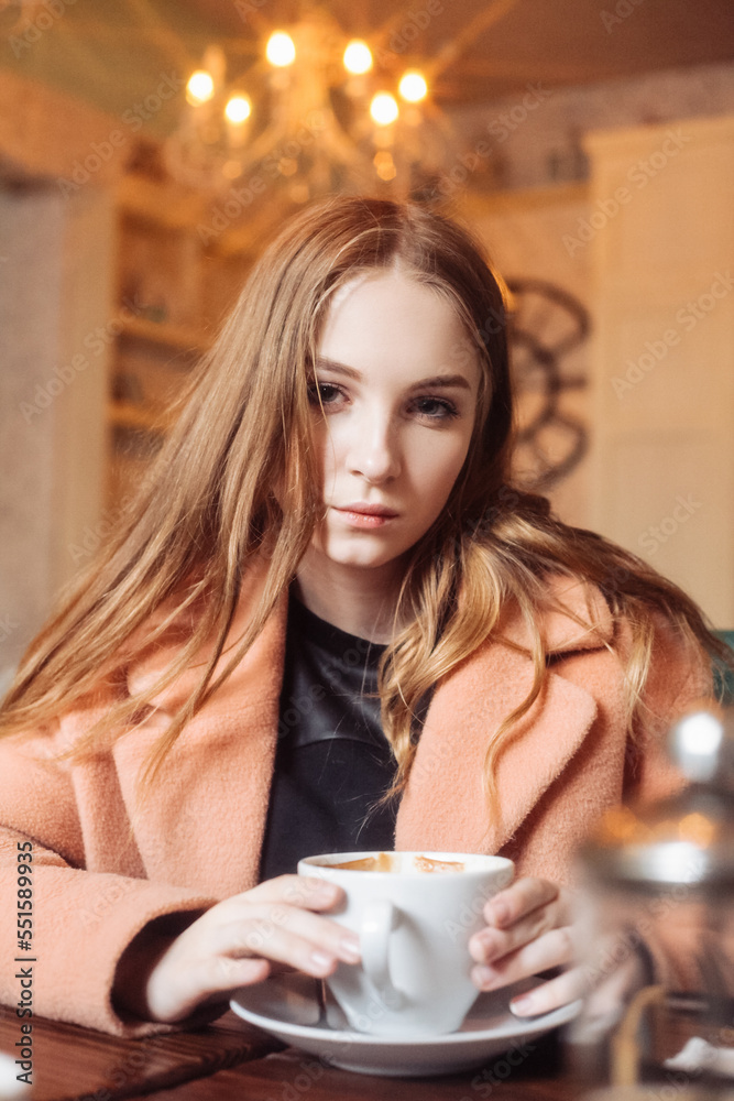 beautiful young woman in a cafe with a cup of coffee beautiful young woman in a cafe with a cup of coffee