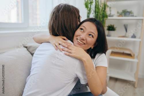 An Asian woman hugs her husband and smiles. The joy of using the family and the good psychological state after the quarrel