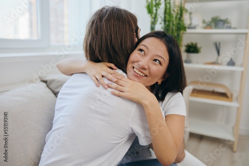 An Asian woman hugs her husband and smiles. The joy of using the family and the good psychological state after the quarrel © SHOTPRIME STUDIO