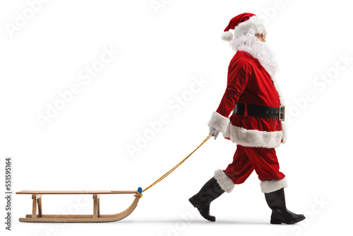 Full length profile shot of santa claus pulling a wooden sleigh photo