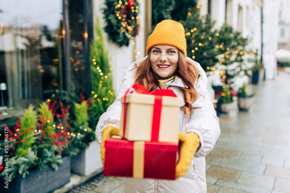Happy young beautiful excited woman holding gift boxes in hands and smile on winter street. Winter holidays sale. Concept of shopping, holidays and happiness christmas. Happy young beautiful excited woman holding gift boxes in hands and smile on winter street. Winter holidays sale. Concept of shopping, holidays and happiness christmas.