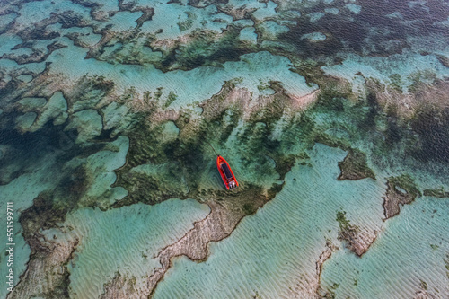Aerial view of a red boat anchored over sand banks, Kuta Mandalika beach, Lombok, Nusa Tenggara, Indonesia photo